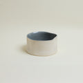 Ceramic container with a blue interior on a beige background