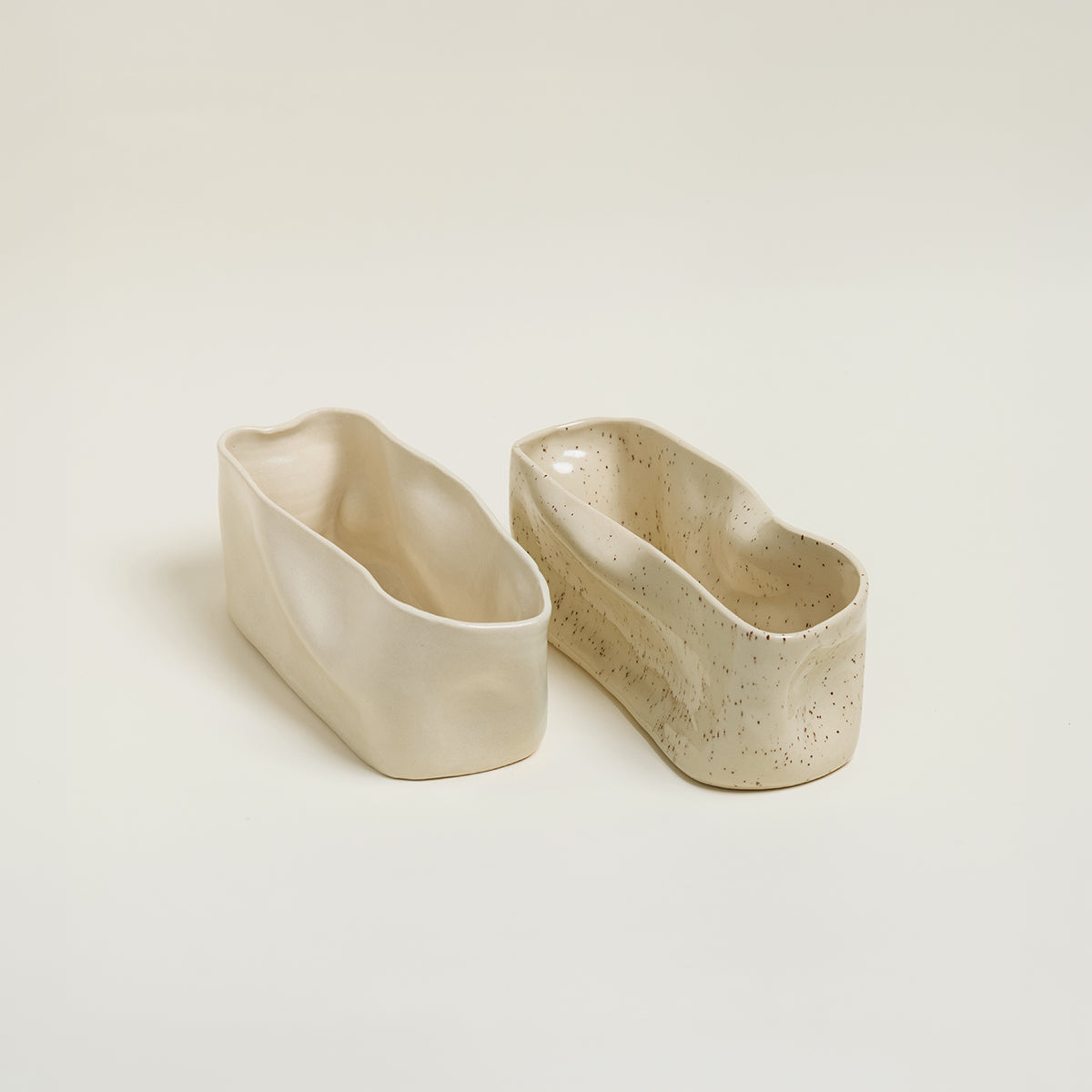 Two ceramic containers on a light beige background