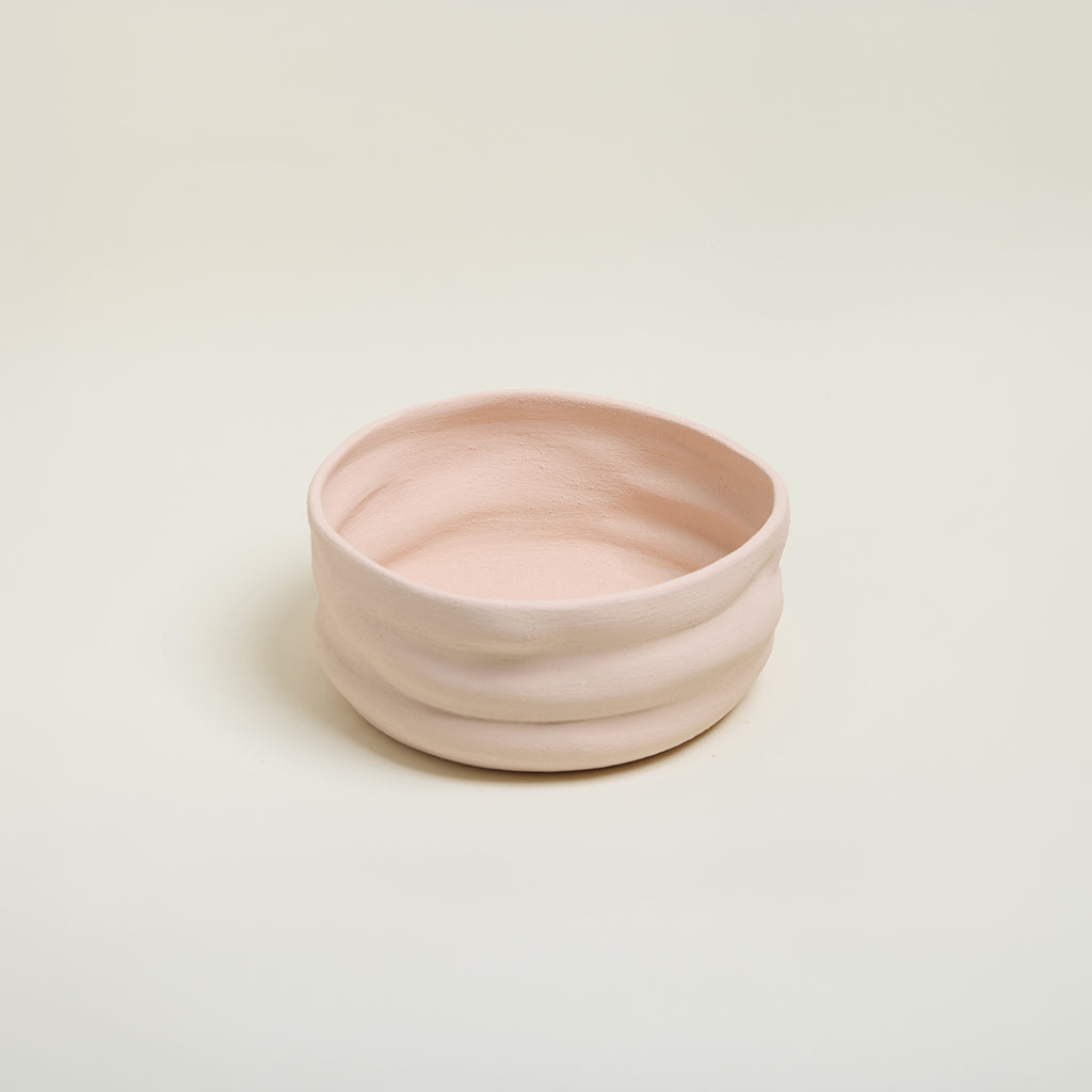 Pink ceramic bowl on a light beige background