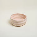Pink ceramic bowl on a light beige background